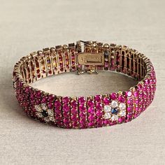 This gorgeous bracelet mimics an 18k gold ruby, sapphire, and diamond bracelet.   It is gold-plated (vermeil) sterling silver with ruby-colored, sapphire-colored, and clear glass (CZ) stones.  The craftsmanship is excellent--each stone is faceted and prong-set.  It has a hidden clasp with safety clasps on either side of the main clasp.  The bracelet is approximately 7 1/4 inches long and 5/8 inches wide.  Weight is 56 g.  In very good condition with no missing stones.   Note:  Vintage jewelry is Jeweled Yellow Gold Bracelets For Formal Occasions, Yellow Gold Jeweled Bracelets For Formal Occasions, Yellow Gold Jeweled Bracelet For Formal Occasions, Formal Yellow Gold Jeweled Bracelets, Elegant Multi-stone Pink Sapphire Jewelry, Elegant Pink Sapphire Multi-stone Jewelry, Luxury Jeweled Yellow Gold Bracelets, Elegant Jeweled Yellow Gold Bracelet, Formal Pink Ruby Bracelets