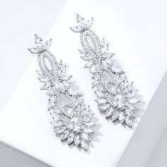 A delightfully unique pair of wedding earrings for the unconventional bride! The flawlessly faceted cubic zirconia stones capture the light in a dazzling array of sparkles, while the delicate links add fluidity and motion. The earrings are rhodium plated for a bright finish which enhances the intricate detailing and conveys a modern take on old elegance. Length: 2.5" (approx. 6.3cm); Width: 0.8" (approx. 2.2cm); Weight: 17g. Hypoallergenic - lead, nickel and cadmium free. This exquisite design w Diamond White Cubic Zirconia Bridal Earrings For Party, Diamond White Cubic Zirconia Chandelier Earrings For Party, Dazzling Cubic Zirconia Bridal Earrings For Evening, Glamorous Cubic Zirconia Chandelier Earrings For Anniversary, Wedding Sparkling Cubic Zirconia Diamond Earrings, Glamorous White Gold Crystal Earrings For Wedding, Wedding Chandelier Earrings In Diamond White Cubic Zirconia, Diamond White Cubic Zirconia Chandelier Earrings For Wedding, Dazzling Cubic Zirconia Chandelier Earrings For Anniversary