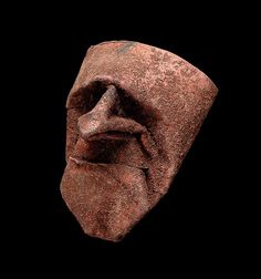 an ancient head is shown against a black background in this image, it appears to be made from clay