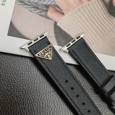 Premium Leather Construction: The Prada Apple Watch replacement strap is made from high-quality leather, ensuring a luxurious feel and long-lasting durability. The leather offers a sophisticated and stylish upgrade to your Apple Watch. Iconic Triangle Monogram Logo: Adorned with Prada's signature triangle monogram logo, the strap showcases the brand's distinctive design and prestigious heritage, adding a touch of elegance to your wrist. Sleek and Elegant Design: The strap features a sleek des... Business Leather Apple Watch Band In Black, Business Black Leather Apple Watch Band, Trendy Black Leather Strap Apple Watch Band, Elegant Black Leather Apple Watch Band, Luxury Black Adjustable Apple Watch Band, Luxury Adjustable Black Apple Watch Band, Luxury Rectangular Black Band Watch Accessories, Luxury Silver Leather Apple Watch Band, Luxury Leather Strap Watch Bands For Business