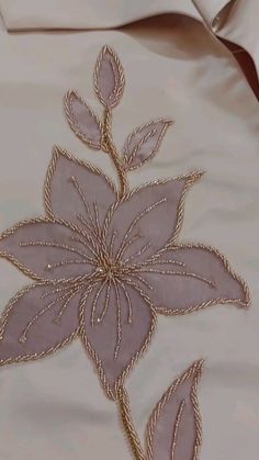 a white shirt with gold embroidered flowers on it