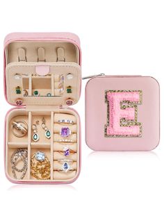 a pink case with jewelry in it and an e on the inside is filled with jewels