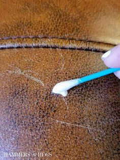 someone is using a toothbrush to brush their teeth on the leather seat of a chair