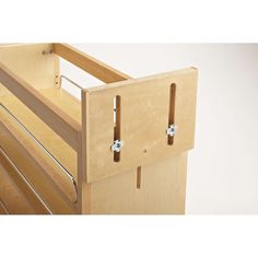 a close up of a drawer on a wooden bed frame with metal bars and handles