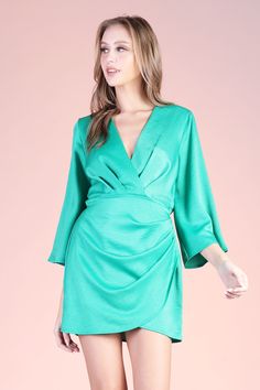 An absolute lux dress! Pair with gold jewelry, a pair of heels and you will be sure to stand out. This piece features mid length kimono - style sleeves and a mini overlay skirt. V neckline Elastic-lined waist Mini length Wrap skirt-area Pullover Semi-textured satin finish 100% Polyester Made in USA SKU #: D-8042 Green Mini V-neck Evening Dress, Chic V-neck Mini Dress With Draped Sleeves, Party Midi Dress With Draped Sleeves And Surplice Neckline, Spring Formal Faux Wrap Dress, Formal Faux Wrap Dress For Spring, Elegant Green Mini Dress With Surplice Neckline, Chic Satin Mini Dress With Draped Sleeves, Satin V-neck Faux Wrap Dress, Party Dress With Faux Wrap And Surplice Neckline