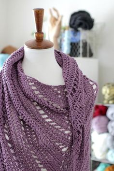 a purple knitted shawl draped over a mannequin