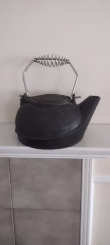 a cast iron teapot sitting on top of a shelf