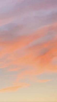 an airplane is flying in the sky at sunset