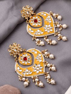 These crescent-moon shaped mustard yellow kundan earrings are the perfect match for any festive outfit, especially when you want to add that extra hint of glamour! They feature a red centre stone to bring a beautiful contrast to the overall look. The earrings have a push-back closure and are comfortable to wear for long durations.  This earring design is also available in a gorgeous pink and a royal blue colour to brighten up your outfits! Kundan Chandbali, Jewelry Pakistani, Crescent Shape, Kundan Earrings, Indian Earrings, Royal Blue Color, Earrings Wedding, Mirror Work, Blue Colour