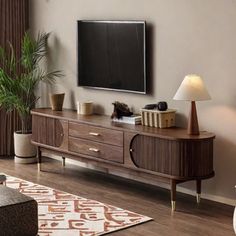 a flat screen tv sitting on top of a wooden entertainment center in a living room