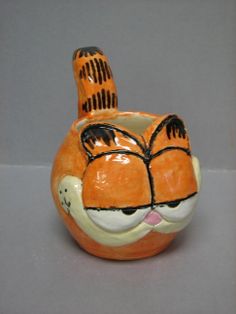 an orange cat shaped vase sitting on top of a table