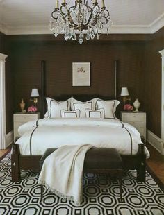 a bedroom with a chandelier hanging from the ceiling and a bed in front of it