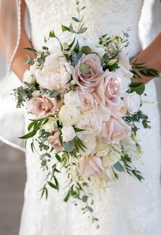 a bridal holding a bouquet of pink and white flowers