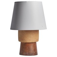 a wooden table lamp with a white shade on the top, and a brown base