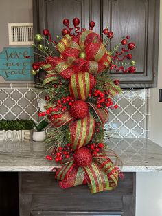 a red and gold christmas bow on top of a counter