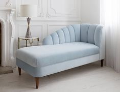 a light blue couch sitting in front of a window