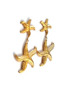 Dive into seaside charm with the "Starfish Earrings" – a delightful pair featuring a larger starfish dangling from a smaller one, both in radiant gold. These earrings capture the whimsy of the ocean, adding a playful touch to your style. Embrace the coastal allure with this charming accessory that evokes the beauty of starfish by the shore. 18k Gold Plated Nickel Free & Hypoallergenic Starfish Earrings, Adventure Style, Resort Collection, Earring Sale, Starfish, The Ocean, The Beauty, 18k Gold, Gold Plate