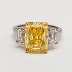 a fancy yellow diamond ring with three baguets