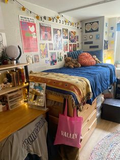 a bed room with a neatly made bed and lots of pictures on the wall