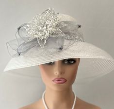 The featured hat is a  silver straw lightweight mesh hat.  The band around the hat is a bright sparkly silver bling strip. The hat is adorned with a  silver crinoline design. In the center of that design is a metal framed flower with wired clear rhinestones. The hat is so dramatic and evocatively romantic it's a must have for any woman who loves hats. Creating the look that suits you best comes from turning the hat on your head creating a different look with each twist till you find the look you love. This classic one of a kind hat made by Letty is a beautiful church hat or a Kentucky Derby Hat.   Also perfect  for  an Easter Hat, Tea Party hat,Wedding Party Hat, Fancy Dress hat, Downton Abby Hat and other special occasions. Brim:   6.5"" curved Rise:   4" Size:    Internal Draw String to Audrey Hepburn Hat, Hat Tea Party, Easter Hat, Downton Abby, Easter Hats, Hat Wedding, Church Hat, Tea Party Hats, Silver Bling