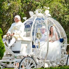 a bride and groom riding in a white carriage