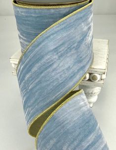 a roll of blue and gold ribbon sitting on top of a table