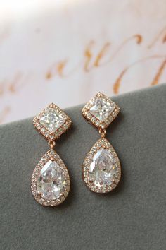 Rose gold vintage style zircon  earrings  Great for you or for your bridesmaids. Colour: rose gold /clear Stud earrings. Measurements: approx 3.5 cm, width approx  x 12mm . Materials:  rhodium over brass  components, zircon crystals. SAME STYLE in silver/blue: https://www.etsy.com/uk/listing/976619935/something-blue-wedding-earrings-for?ref=shop_home_active_1 SAME STYLE in silver/clear tone: https://www.etsy.com/uk/listing/962646758/wedding-earrings-for-brides-art-deco?ref=shop_home_active_2 Gre Wedding Rose Gold Dangle Diamond Earrings, Wedding Rose Gold Diamond Dangle Earrings, Rose Gold Elegant Diamond Earrings For Wedding, Rose Gold Dangle Diamond Earrings For Wedding, Exquisite Diamond Drop Earrings For Wedding, Classic Gold Chandelier Earrings For Anniversary, Elegant Rose Gold Chandelier Earrings For Weddings, Elegant Rose Gold Teardrop Earrings For Wedding, Elegant Rose Gold Teardrop Earrings For Anniversary