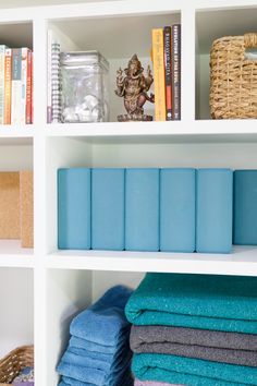 the shelves are filled with folded towels and other things to use as storage for books