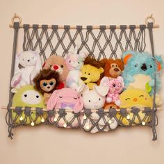 a bunch of stuffed animals are in a wire basket with lights on the wall behind them