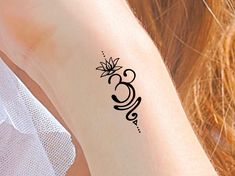 a woman's arm with a tattoo on it that has the letter b in black ink