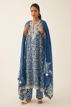 Blue asymmetric kalidar kurta with floral, mughal hand block print and sequin, tassel, bead work on neckline and sleeve hem. Paired with cotton slip, chevron hand block print straight pant and dupatta with printed border on the edges.
Components: 4
Pattern: Hand Block Printed, Embroidery
Type Of Work: Floral, chevron, sequin, bead, tassel
Neckline: Notched
Sleeve Type: Three quarter
Fabric: Kurta: Cotton Chanderi, Slip and Pant: Cotton, Dupatta: Silk Chanderi
Color: Blue
Other Details: 
Elastica Kalidar Kurta, Printed Embroidery, Kurta Cotton, Blue Kurta, Cotton Slip, Cotton Dupatta, Straight Pants, Set For Women, Aza Fashion