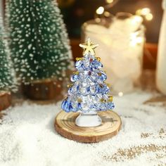 a small glass christmas tree sitting on top of a table