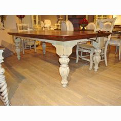 a dining room table with chairs around it and wood flooring on the other side