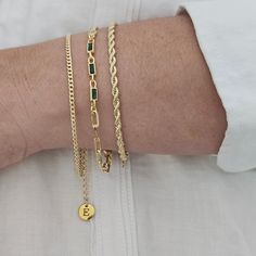 Discover beauty and personalization with our elegant set of 3 gold bracelets, decorated with crystals, making them the perfect accessory for any occasion. Personalize each piece with letters or symbols that represent your values, special moments or your loved ones. Cuidados: Para mantener el brillo de tus pulseras, evita el contacto con productos químicos y guárdalas en un lugar seco. Exprésate y lleva contigo un mensaje especial con este hermoso set de pulseras personalizadas. ¡Haz tu pedido ho Baguette Bracelet, Gold Arm Band, Bracelet Layering, Green Charms, Gold Bracelet Set, Gold Armband, Gold Bracelets, Your Values, Layered Bracelets