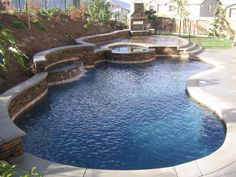 an outdoor swimming pool with steps leading to it and a fire pit in the middle