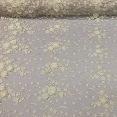 the fabric is made with white flowers on light gray background, and it looks like something out of wonderland