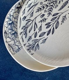 two white plates with blue designs on them