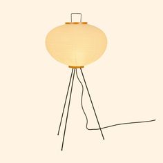 the floor lamp is made out of metal and has a round light shade on it