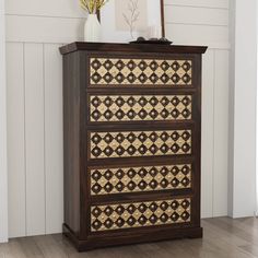 a wooden dresser sitting on top of a hard wood floor next to a white wall