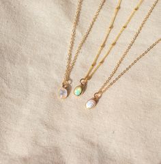 Our Dainty gemstone necklace features a tiny little stone, choose between opal, moonstone and turquoise.  DETAILS *PENDANT is Genuine Turquoise, Genuine Moonstone, or Synthetic Opal, measuring 5 x 7mm *CHAIN is 14k Gold Filled or Sterling Silver *CLASP is 14k Gold Filled or Sterling Silver Matching  PERSONALIZE IT!  ADD A STAR INITIAL CHARM: https://www.etsy.com/ca/listing/627638174/add-a-star-initial-charm ADD A STAMPED INITIAL: https://www.etsy.com/ca/listing/561708083/add-an-initial ADD A BIR Gold Opal Necklace, Purple Flower Necklace, Dainty Gemstone Necklace, Opal Moonstone, Dainty Initial Necklace, Necklace Birthstone, Gemstone Pendant Necklace, Synthetic Opal, Moonstone Necklace