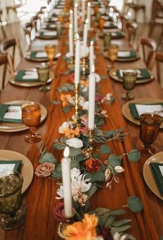 a long table with candles and flowers on it is set up for a formal dinner