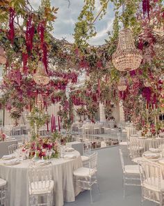 tables and chairs are set up for a wedding reception with chandeliers hanging from the ceiling