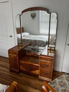 a bedroom scene with focus on the dresser and bed in the background, as well as a mirror