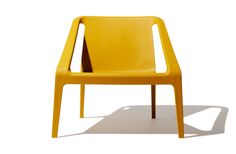 a yellow plastic chair sitting on top of a white floor