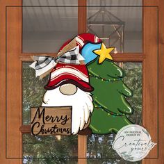 a merry christmas sign hanging from the side of a window with a santa clause hat on it