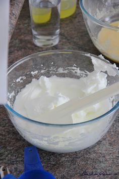 a mixing bowl filled with white batter on top of a counter next to other ingredients