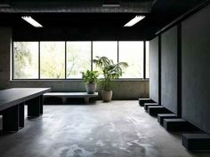 an empty room with benches and plants in it