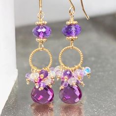 Purple Lavender Amethyst Earrings, Violet Gem Dangle Earrings, Multi Gemstone Cluster Earring, Fall Wedding Jewelry, Gift for Sister Beautiful violet quartz faceted briolettes dangle on gold vermeil twisted rings with wire wrapped gemstone rondelles of pink amethyst, violet quartz, lavender and purple amethyst and rainbow moonstone (with visible blue flashes!) to create these unique, elegant handmade earrings. These super sparkly drops of violet quartz dangle beneath the rondelles that are all m Purple Teardrop Chandelier Earrings As Gift, Purple Briolette Earrings For Wedding, Purple Round Earrings With Gemstone Accents, Round Purple Earrings With Gemstone Accents, Lavender Briolette Gemstone Earrings, Purple Amethyst Earrings For Wedding, Purple Gemstone Accented Round Earrings, Purple Drop Earrings With Gemstone Accents, Purple Gemstone Accented Drop Earrings