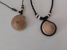 two necklaces made out of shells on a white surface