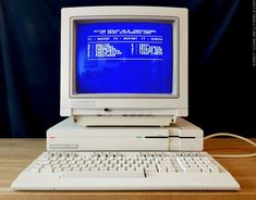 an old computer sitting on top of a wooden table